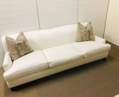 A large off white three seater upholstered sofa on six bun feet designed and upholstered by Gary Andrews Upholstery with two 