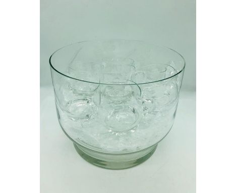 An engraved glass punch bowl with ladle and nineteen cups in total, ten in one style and nine in another.