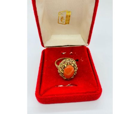 A 9ct yellow gold ring with a coral centre stone