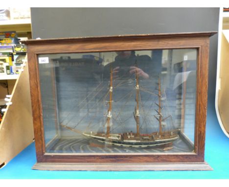 A model sailing ship in oak glazed case