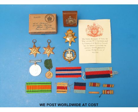 Three WWII medals, together with a Dorsetshire Regiment cap badge, and one other, a white metal mounted medallion, an eighth 