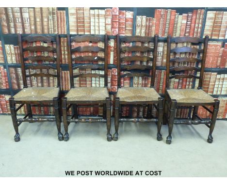 Four rush-seated oak ladder back chairs