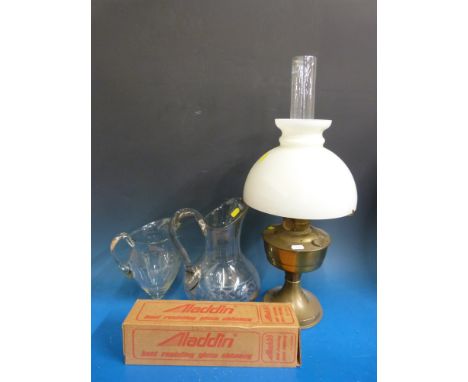 An oil lamp with glass shade and two large glass jugs