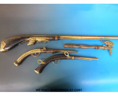 A pair of replica pistols with brass fittings, a similar shotgun and an axe