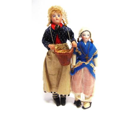 TWO 19TH CENTURY BISQUE SHOULDER HEAD DOLLS  each with integrally fashioned costume, the largest 26cm high.