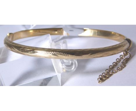 9 CT BANGLE. 9 ct gold engraved hinged bangle