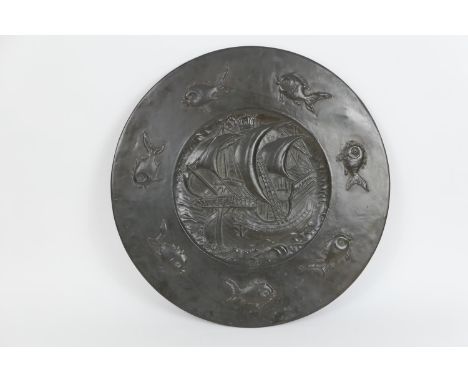 Attributed to John Pearson, (Newlyn), hand hammered copper plaque, centred with a sailing galleon and bordered with fish, 61.