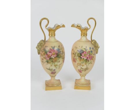 Pair of Royal Worcester peach ground pedestal ewers, circa 1911, ovoid form with Bacchanalian mask handle and decorated with 