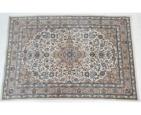 Iranian Tabriz woollen carpet, fawn field dispersed with blue palmettes and centred with a blue flowerhead against a light br