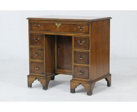 Walnut and inlaid kneehole desk, the top centred with an oval inlay within a feather and crossbanded border, the front with a