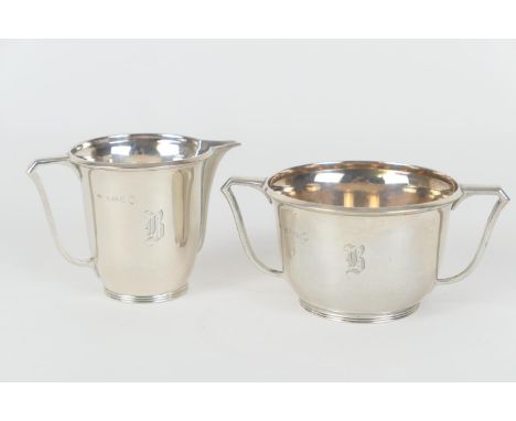 George V silver sugar basin and matching cream jug, by Adie Bros., Birmingham 1935, each of plain form engraved with a Gothic