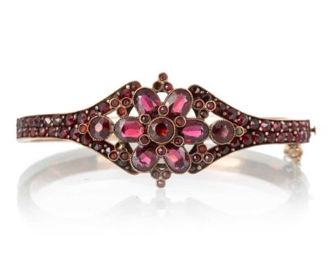VICTORIAN FLOWER CLUSTER BANGLE, set with garnets and red paste stones, unmarked