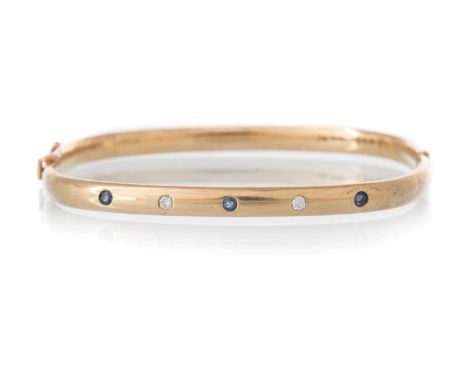 SAPPHIRE AND DIAMOND BANGLE, of rounded square form, set with five small alternating sapphires and diamonds, in nine carat go