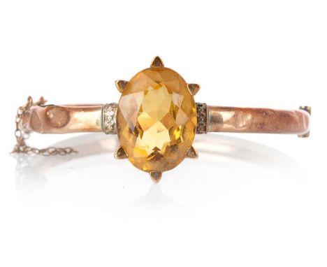 CITRINE BANGLE, with a central claw set citrine, marked 9CTQty: 14.8gVery poor condition - see images.