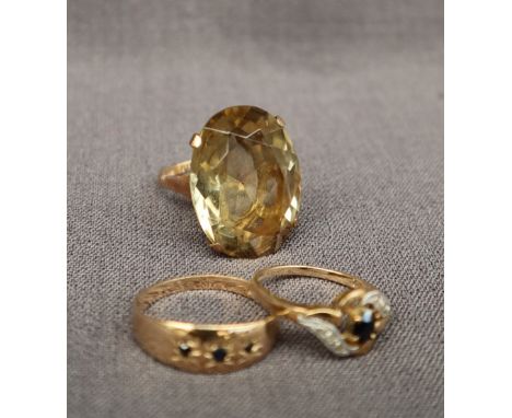 A citrine dress ring with an oval faceted citrine to a 9ct gold setting and shank, size M, together with a sapphire three sto