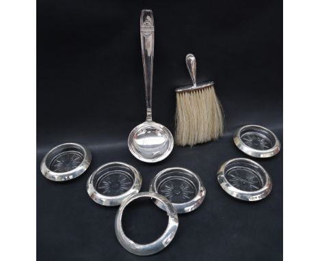 A silver photograph frame or rectangular form together with five silver topped coasters, silver handled brush and white metal