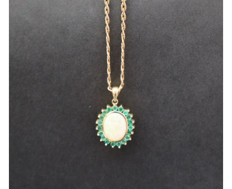 An emerald and opal pendant of oval form set with a central opal and nineteen emeralds to yellow metal claw setting  on a 9ct