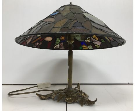 A 20th Century leaded glazed table lamp in the manner of Tiffany, the polychrome decorated shade inset with panels of child f