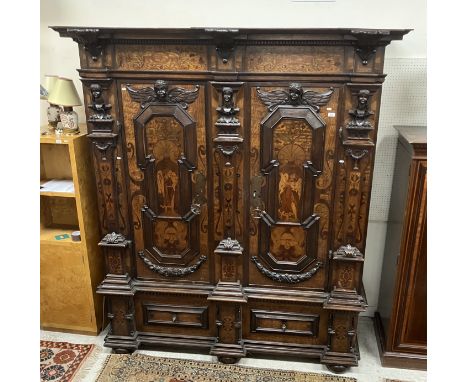 A 19th Century Alsatian Baroque Revival oak and inlaid kas or cupboard, the moulded cornice with foliate carved applied corbe