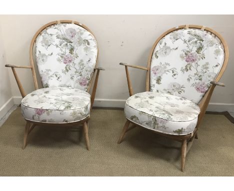 A pair of Ercol beech framed stick back elbow chairs with cushioned back and seat on turned legs united by stretchers, 74.5 c