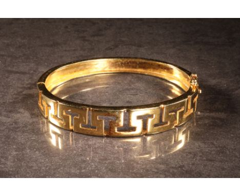 An 18 carat gold Greek key style openwork decorated bangle, 6 cm wide, 34.7 g