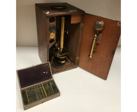 A Victorian lacquered brass monocular microscope by James Parkes & Son of Birmingham raised on a cabriole tripod base, bears 