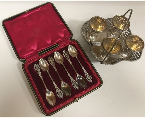 A Victorian silver pierced latticework decorated egg cruet with swing handled basket and four cups raised on four ball feet (