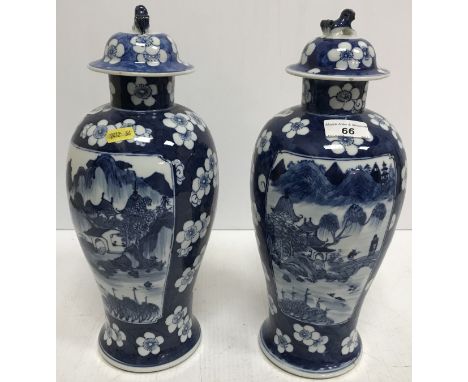 A pair of Chinese blue and white baluster shaped vases and covers, the main bodies decorated with watery landscapes and figur