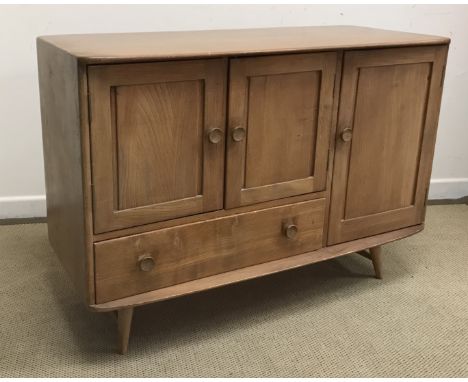 An Ercol elm sideboard of shallow bow fronted form, the plain top over two cupboard doors and drawer and a larger cupboard do