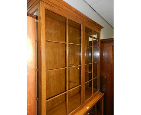 A light oak display cabinet with ribbed glazed double doors to the upper and lower sections, 131cm wide, 40cm deep, 221cm hig