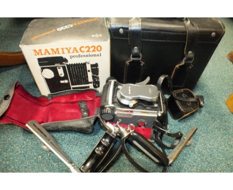 A Mamiya C-220 Professional twin-lens reflex roll film camera and accessories including remote flash arm, carry case, additio