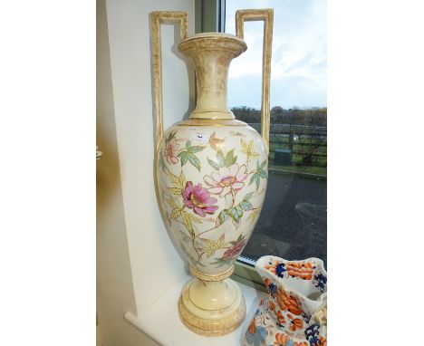 A large late 19th/early 20th century decorative vase of amphora shape with twin bracket handles decorated with flowers and fo