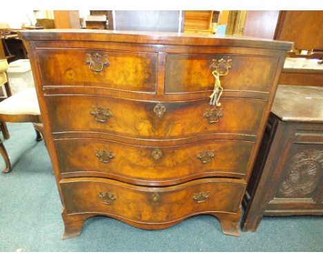 A George III style quarter veneered figured walnut and crossbanded serpentine front chest of two short and three long graduat