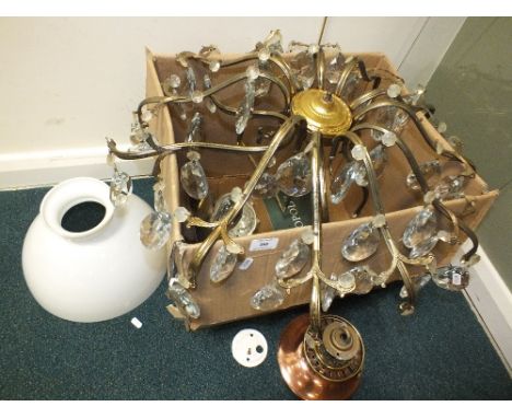 A twelve branch gilt metal chandelier with pendant cut drops also a hanging paraffin lamp with copper reservoir and milk glas