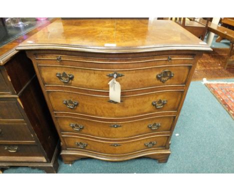 A George III style quarter veneered crossbanded and figured walnut serpentine front bachelor's chest with brushing slide abov