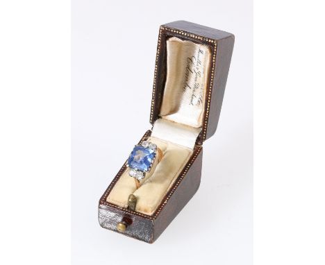 Unhallmarked yellow metal five stone dress ring set with central faceted blue stone flanked by four diamonds, six K/L, 3.1g. 