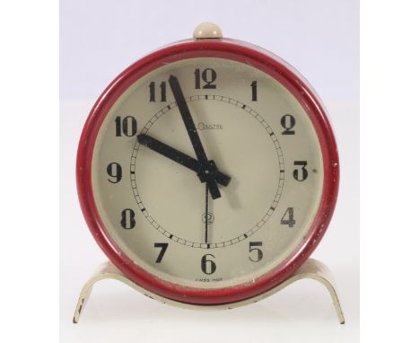 Le Coultre drumhead alarm clock with burgundy red metal bezel on serpentine stand, 7cm.