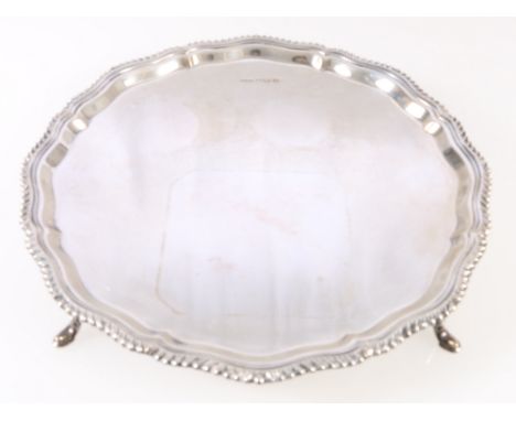 Silver salver with gadrooned edge raised on four feet, maker 'K Ltd', 518g, 25.5cm.