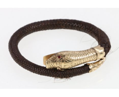 Woven hair bracelet set with yellow metal mounts in the form of a serpent with ruby set eyes. CONDITION REPORT: Some wear/spl