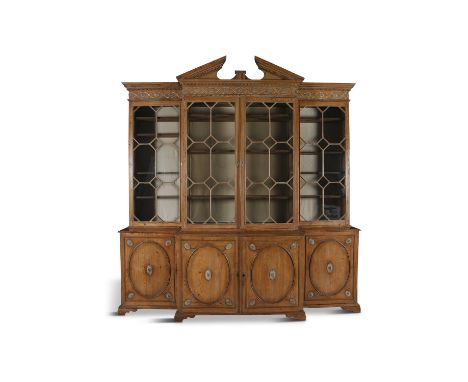A LARGE EARLY 19TH CENTURY PINE BREAKFRONT BOOKCASE, the central broken triangular pediment with moulded dentil cornice, abov