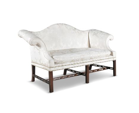 A GEORGE III STYLE MAHOGANY FRAMED SHORT CAMEL BACK SOFA, with double scroll ends, on square chamfered legs with pierced stre