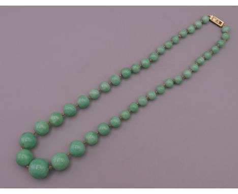 A string of jade beads. 44 cm long.