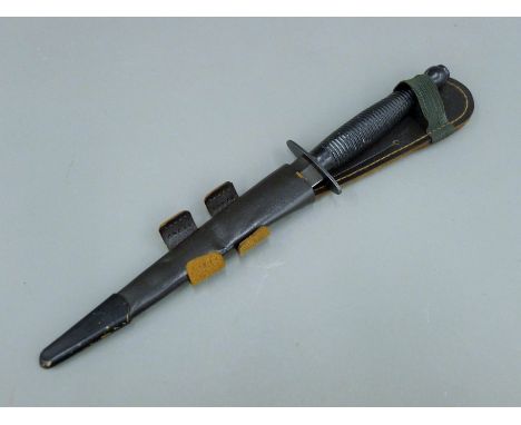 A Sykes-Fairbairn SAS Commando dagger, with etched blade ''Who Dares Wins'', with leather sheath. 32 cm long overall.