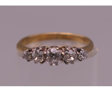 An unmarked 18 ct gold five stone diamond ring. Ring size J/K. 1.9 grammes total weight.