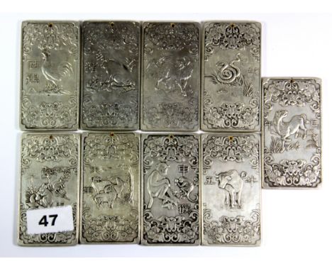 Nine Chinese white metal amulet / scroll weights, H. 9.5cm.