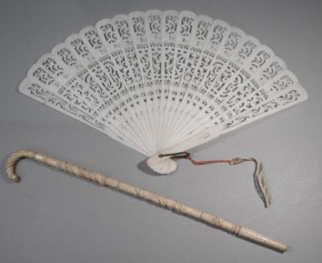 EARLY C20th JAPANESE IVORY FAN, PIERCED AND WORKED (W: 31 cm WHEN OPEN) TOGETHER WITH A MINIATURE CARVED BONE WALKING STICK (