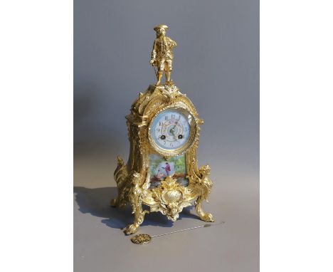 A 19th century French gilt metal and porcelain eight day mantel clock, with figural pediment, height 43cm