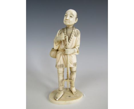 A Meiji Japanese carved ivory sectional okimono modelled as a fisherman with trident, 13.5 cm high