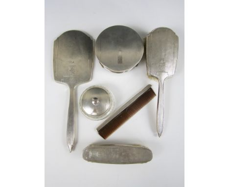 An Edward VIII silver six piece dressing table set, comprising jewellery box, trinket box, hand mirror, hair brush, clothes b