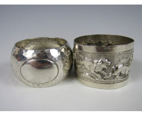 A George V planished silver napkin ring, Walker & Hall, Sheffield, 1910, together with one other white-metal napkin ring, dec